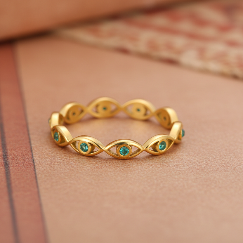 Gold ring with green gemstones and a measurement label on a white background