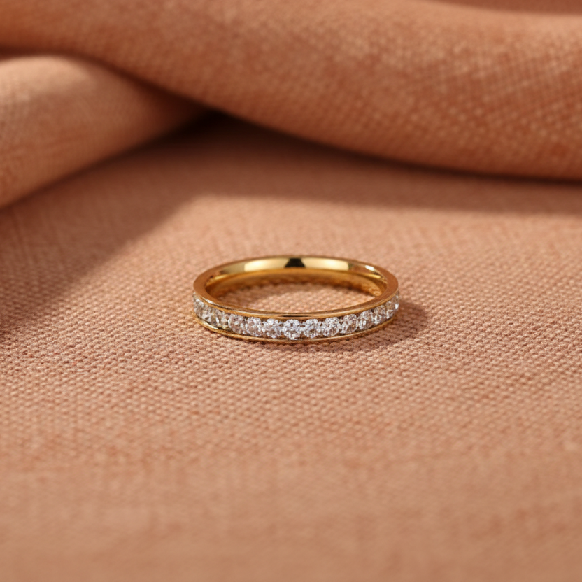 Three gold rings with different designs on a light beige background